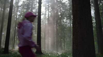 a person in a pink hat walking through a forest