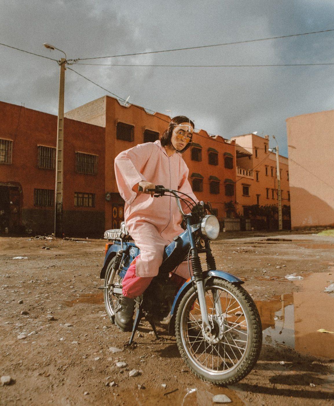 a woman in pink is sitting on a motorcycle