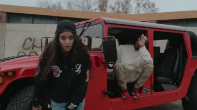 a man and a woman sitting in the back of a red jeep