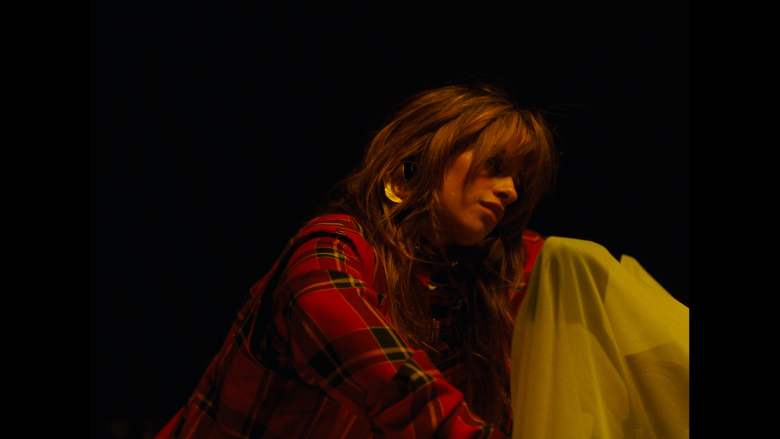 a woman in a plaid shirt holding a white bag