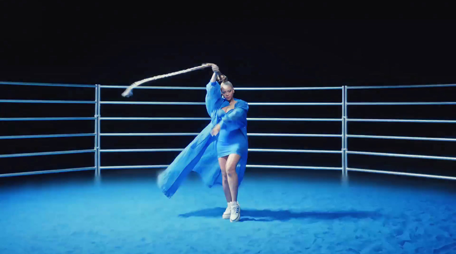 a woman in a blue dress is dancing on a stage