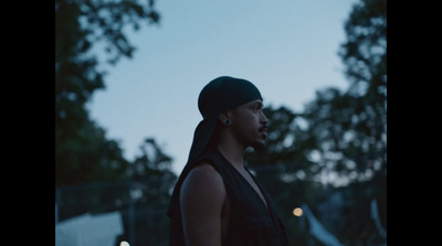 a man standing in front of a fence at dusk