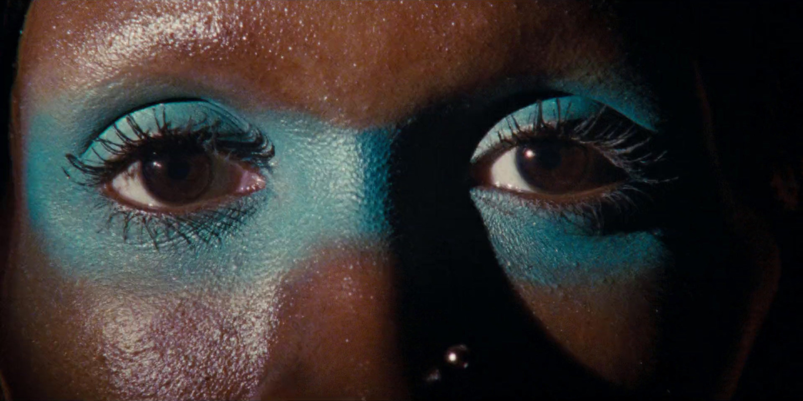 a close up of a woman's face with blue makeup