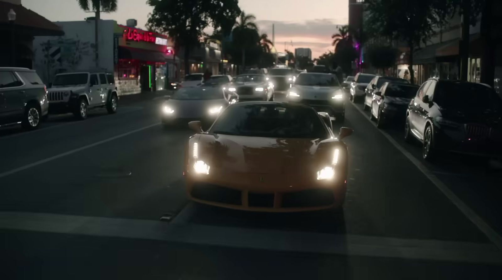 a group of cars driving down a street at night