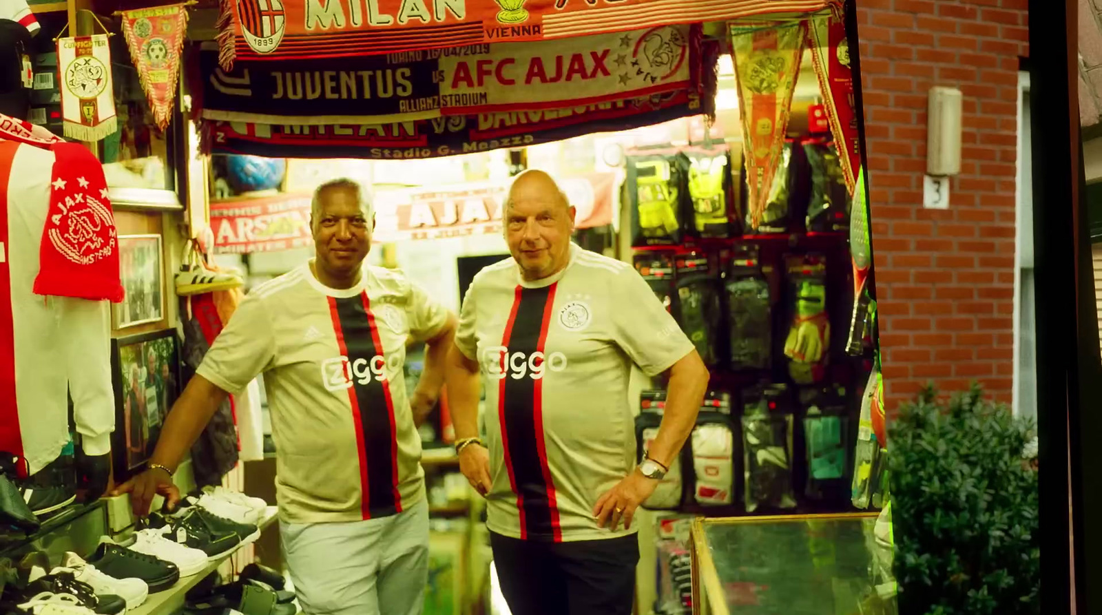 two men standing in front of a store