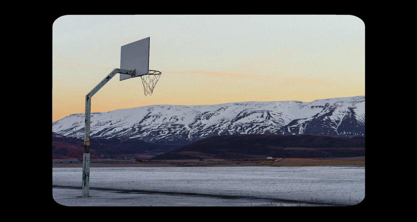 a basketball hoop in front of a snowy mountain