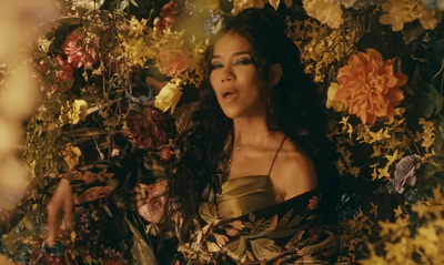 a woman standing in front of a bunch of flowers