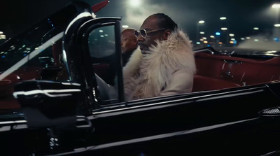 a man in a fur coat sitting in a car