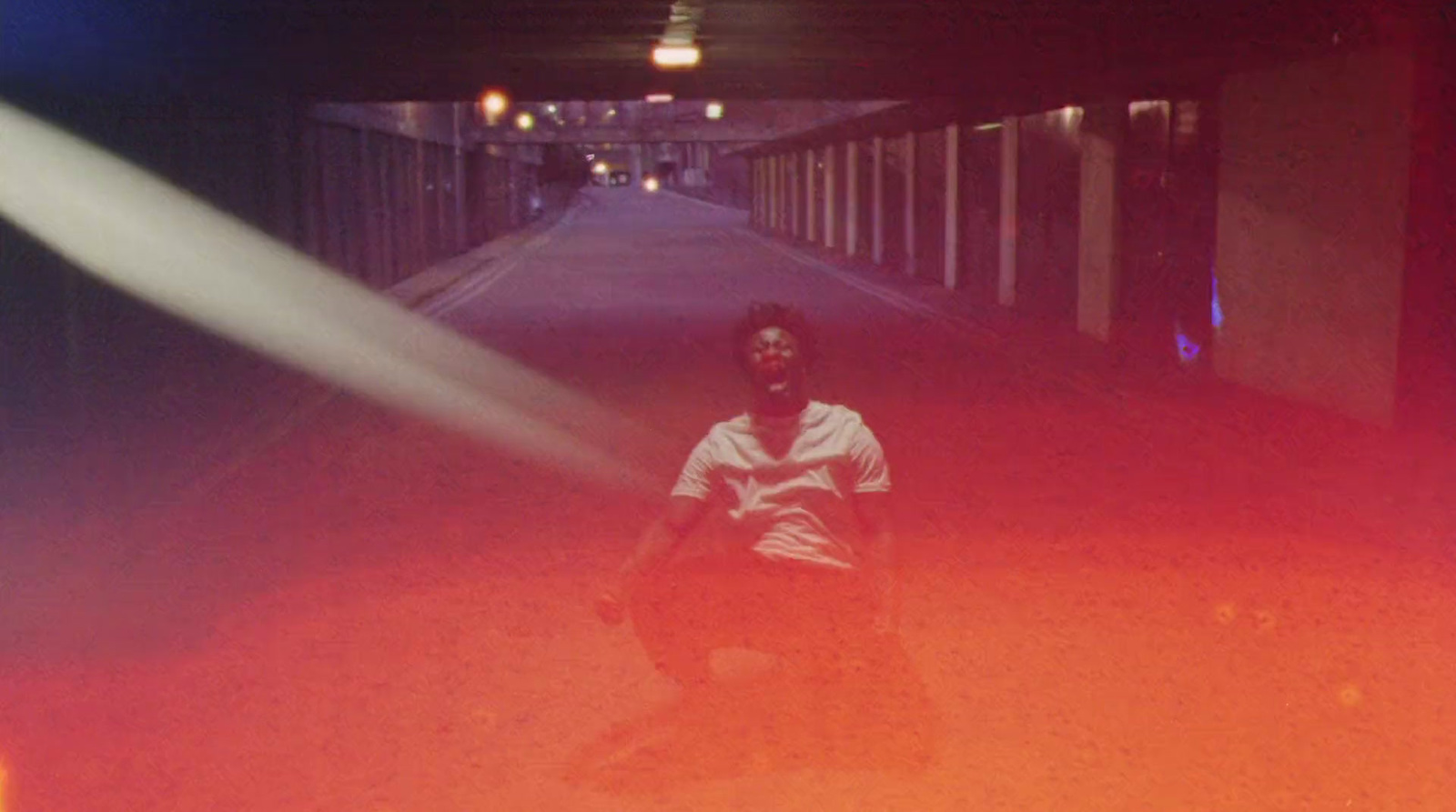 a man sitting on a skateboard in a tunnel