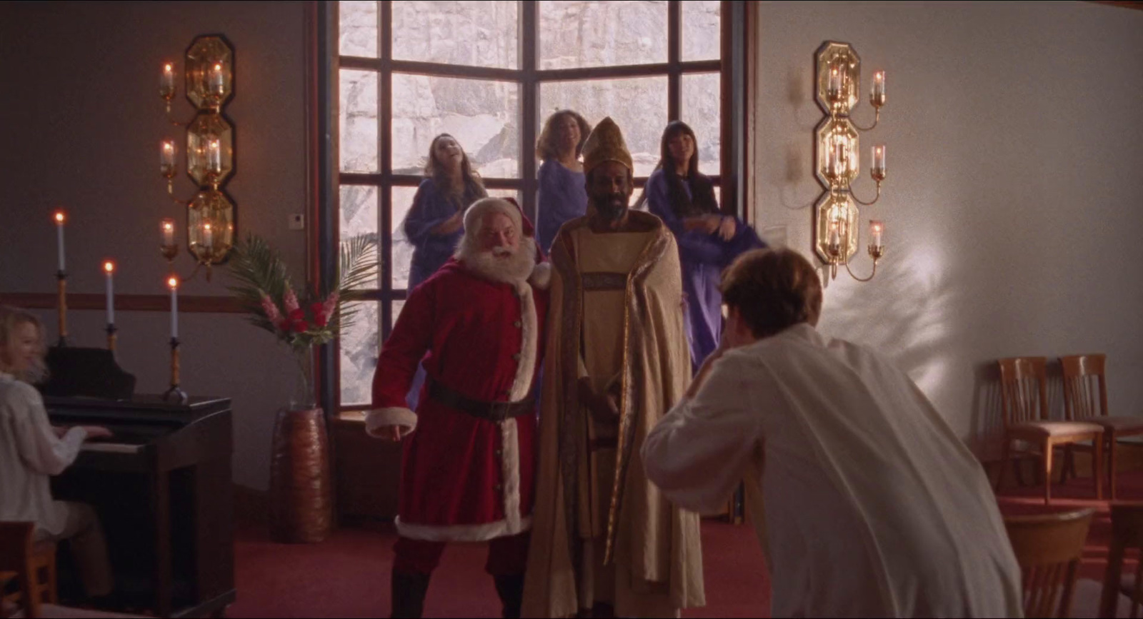 a man dressed as santa claus standing in front of a group of people