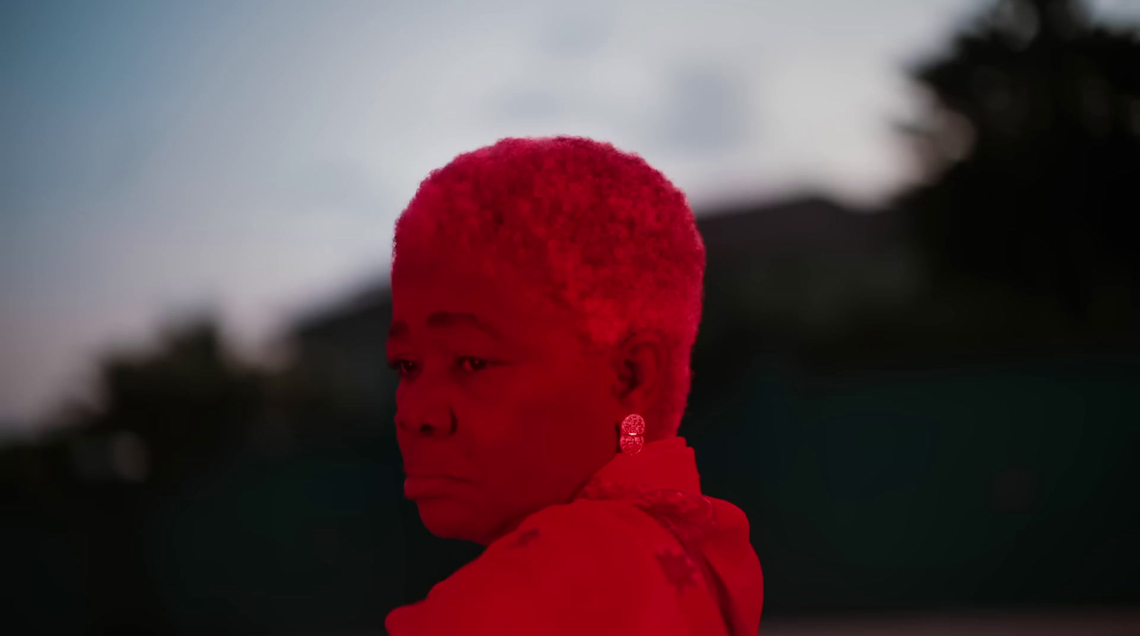 a woman with red hair and earrings on