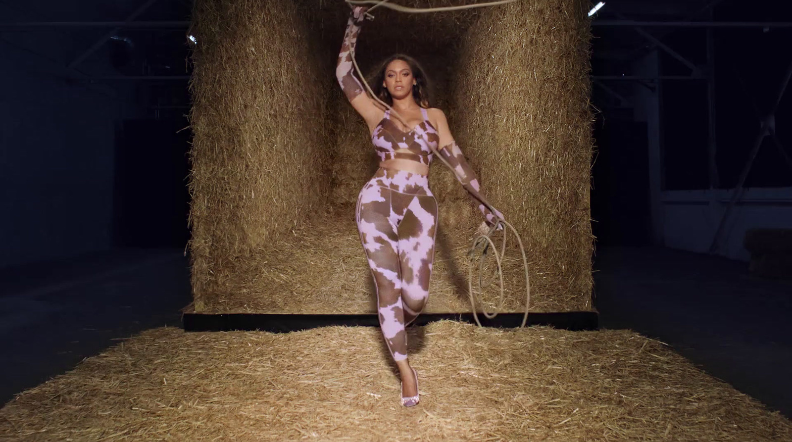 a woman in a cow print outfit holding a rope