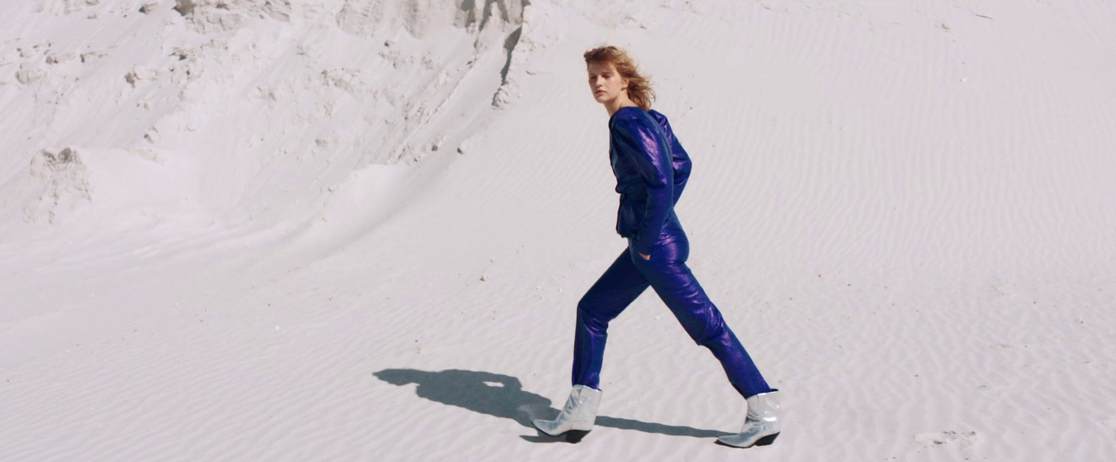 a woman in a wet suit walking in the snow