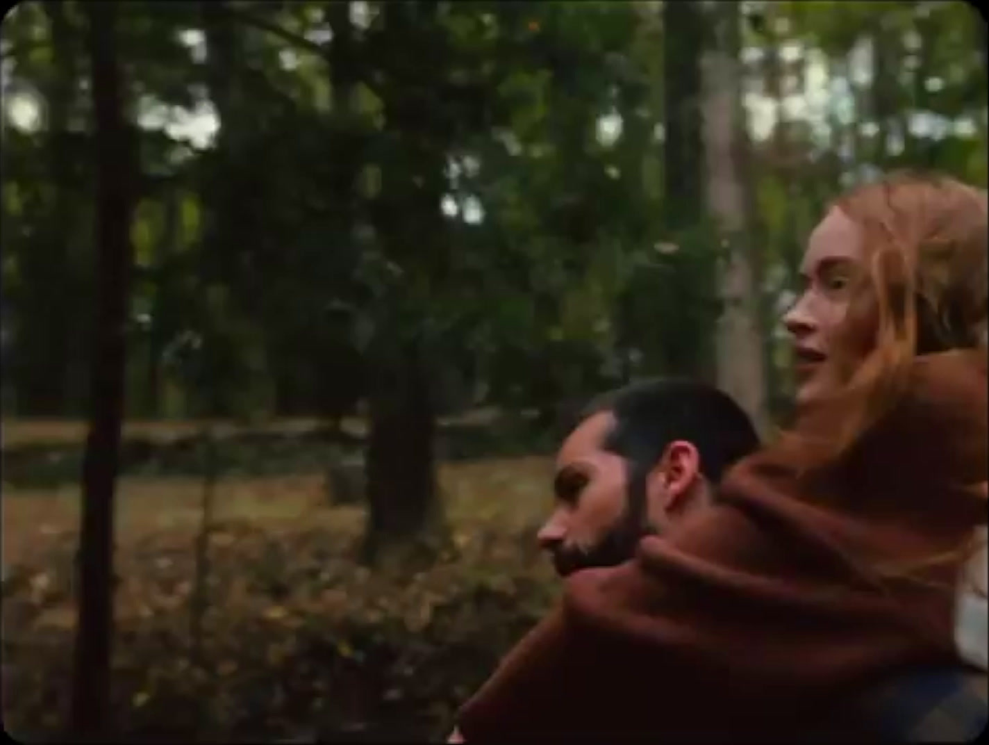 a man carrying a woman in the woods