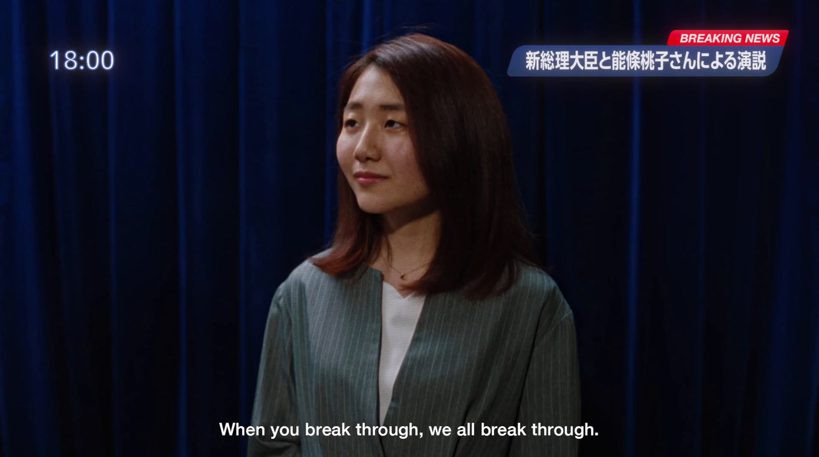 a woman standing in front of a blue curtain