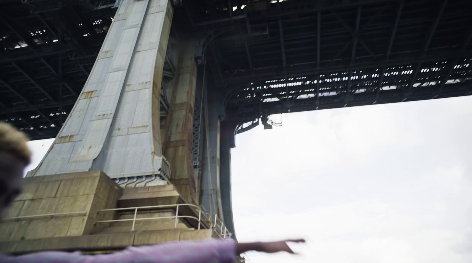 a person flying a kite under a bridge