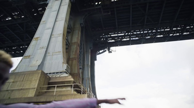 a person flying a kite under a bridge