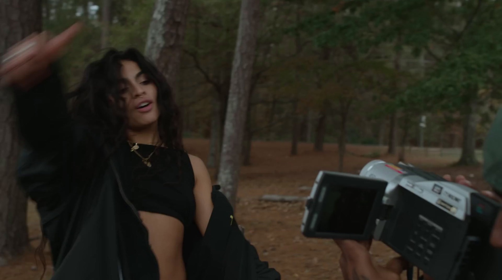 a woman in a black dress holding a camera