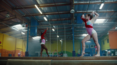 a couple of women standing on top of a balance beam