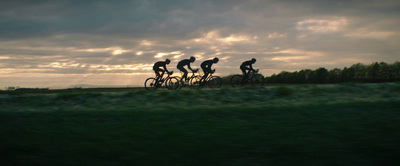 a group of people riding bikes down a lush green field