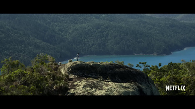 a person standing on top of a large rock