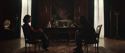 a man and a woman sitting at a table in a dark room