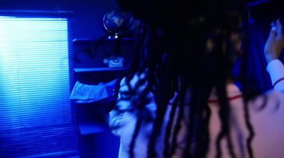 a woman with dreadlocks standing in a dark room