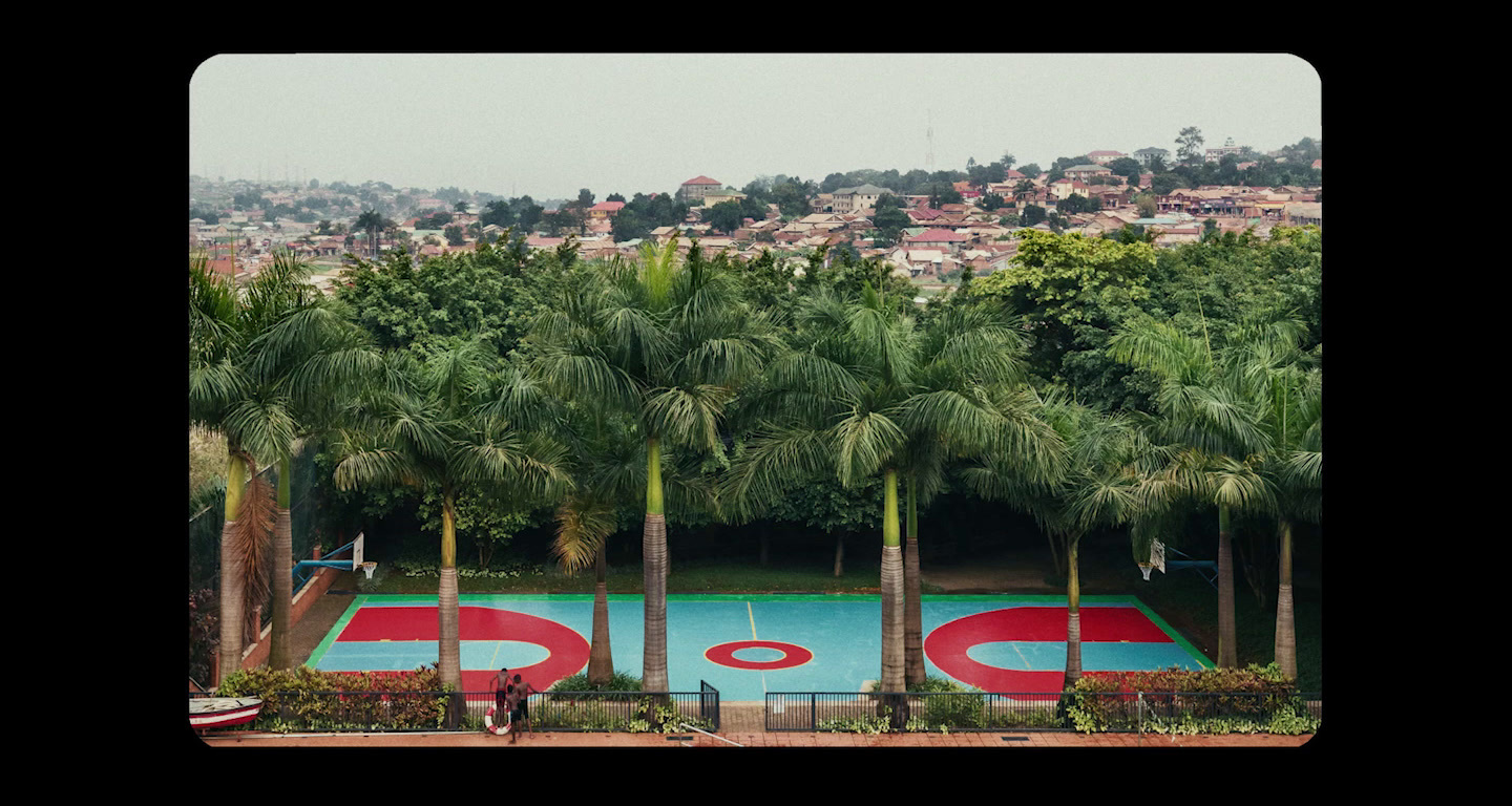 a pool surrounded by palm trees with a city in the background