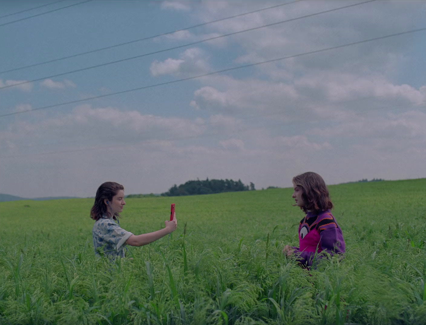 a couple of women standing in a lush green field