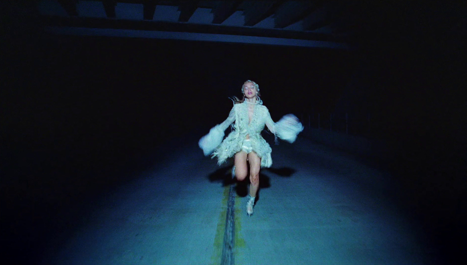 a woman in a white dress is sitting in the dark