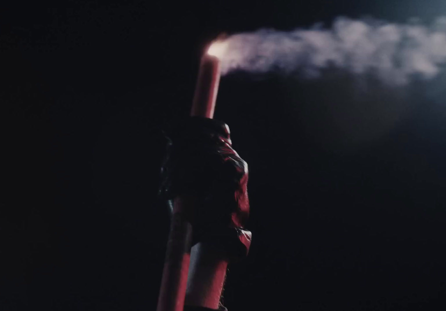 a person is holding a pole with smoke coming out of it