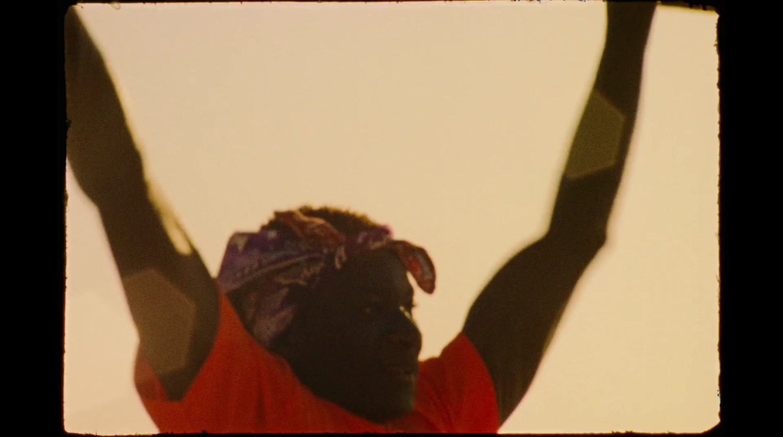 a woman in a red shirt is holding her arms up