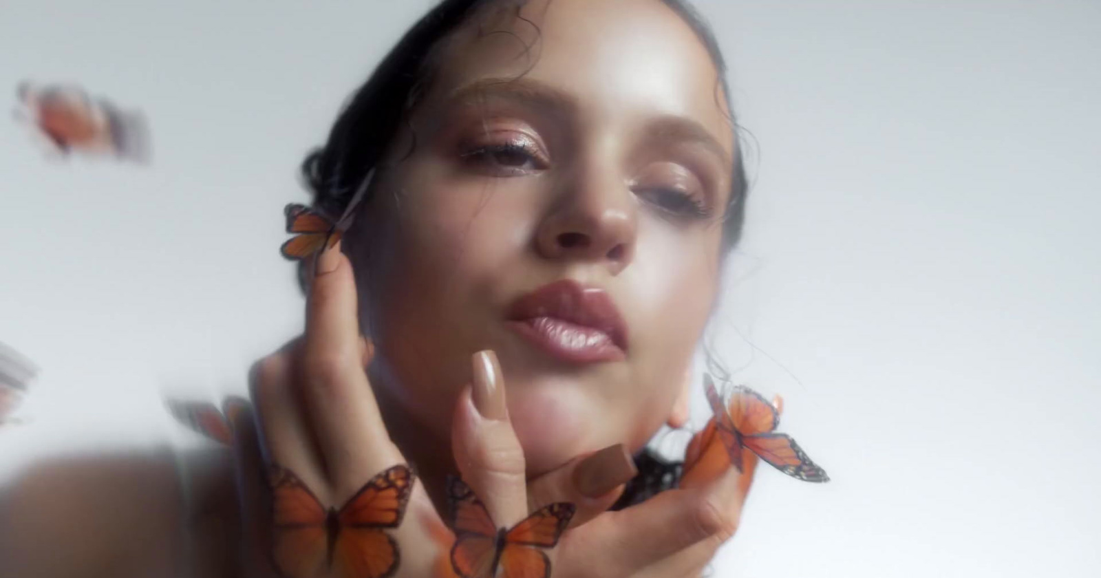 a woman with butterflies around her neck and hands