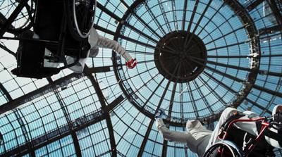 a man in a wheel chair in front of a glass ceiling