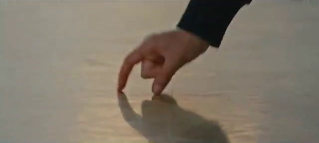 a person's hand pointing at something in the water