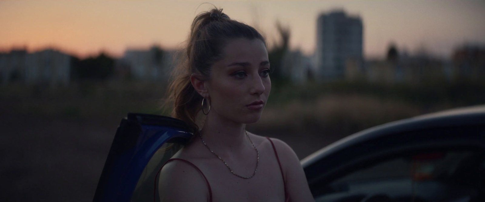 a woman standing next to a parked car