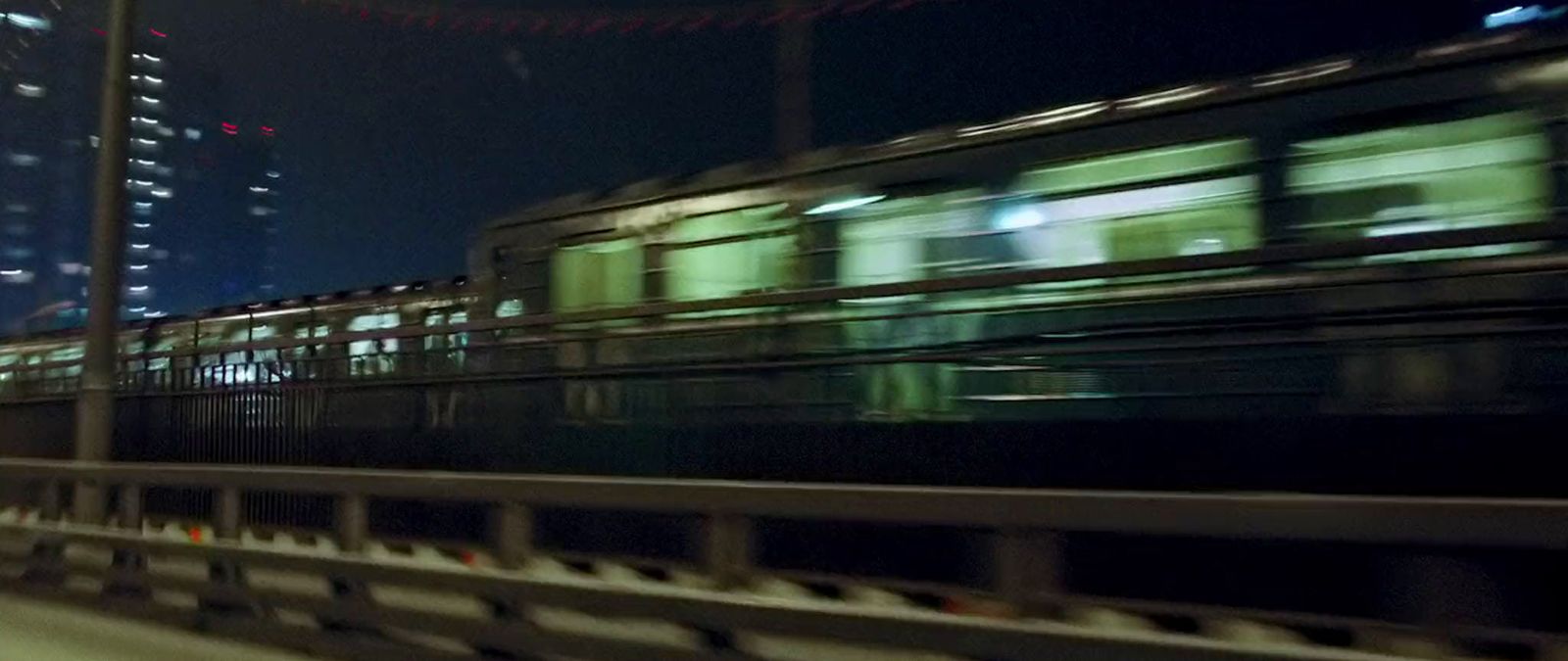 a blurry photo of a train traveling through a city at night