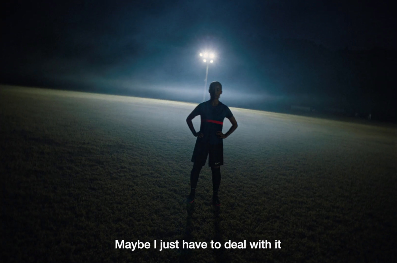 a man standing in the middle of a field at night