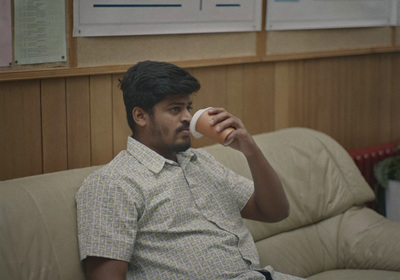 a man sitting on a couch holding a doughnut