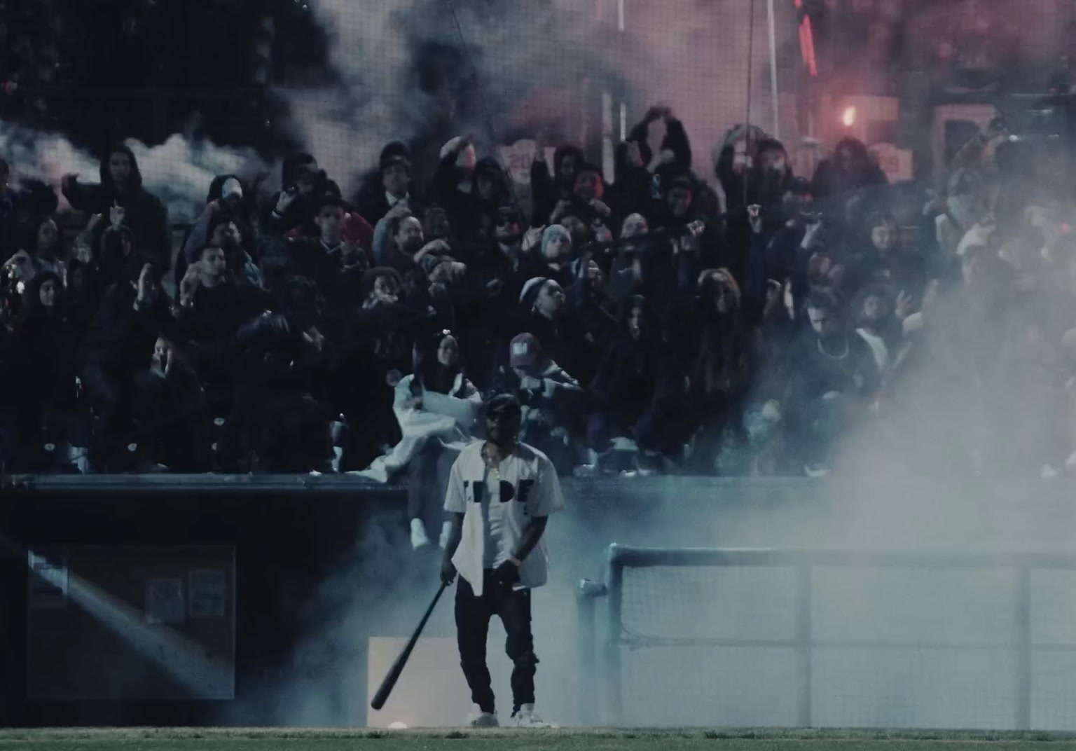 a man holding a baseball bat in front of a crowd of people