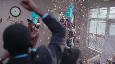 a man in a room with confetti and a clock