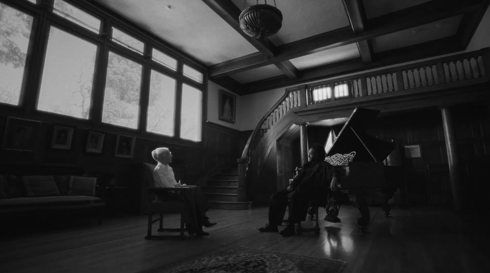 a man sitting in a chair in front of a piano