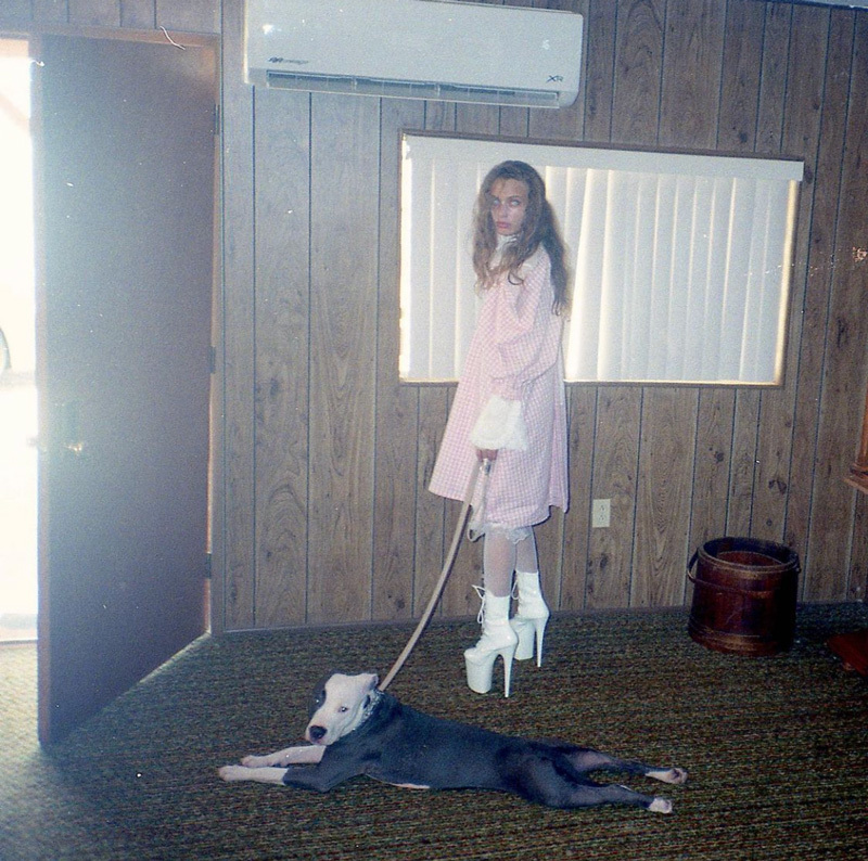 a young girl standing next to a dog on a leash