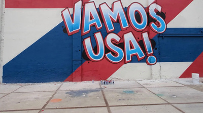 a large mural of the word vamos usa painted on the side of a building