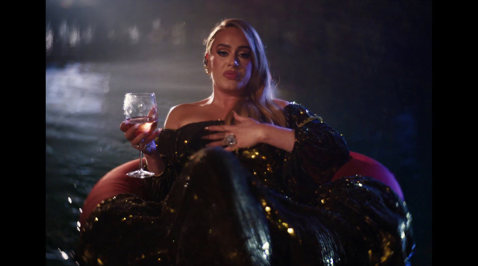 a woman sitting in a chair holding a glass of wine