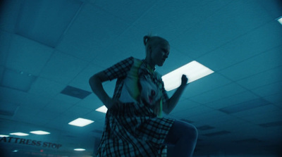 a woman standing in a room holding a cell phone