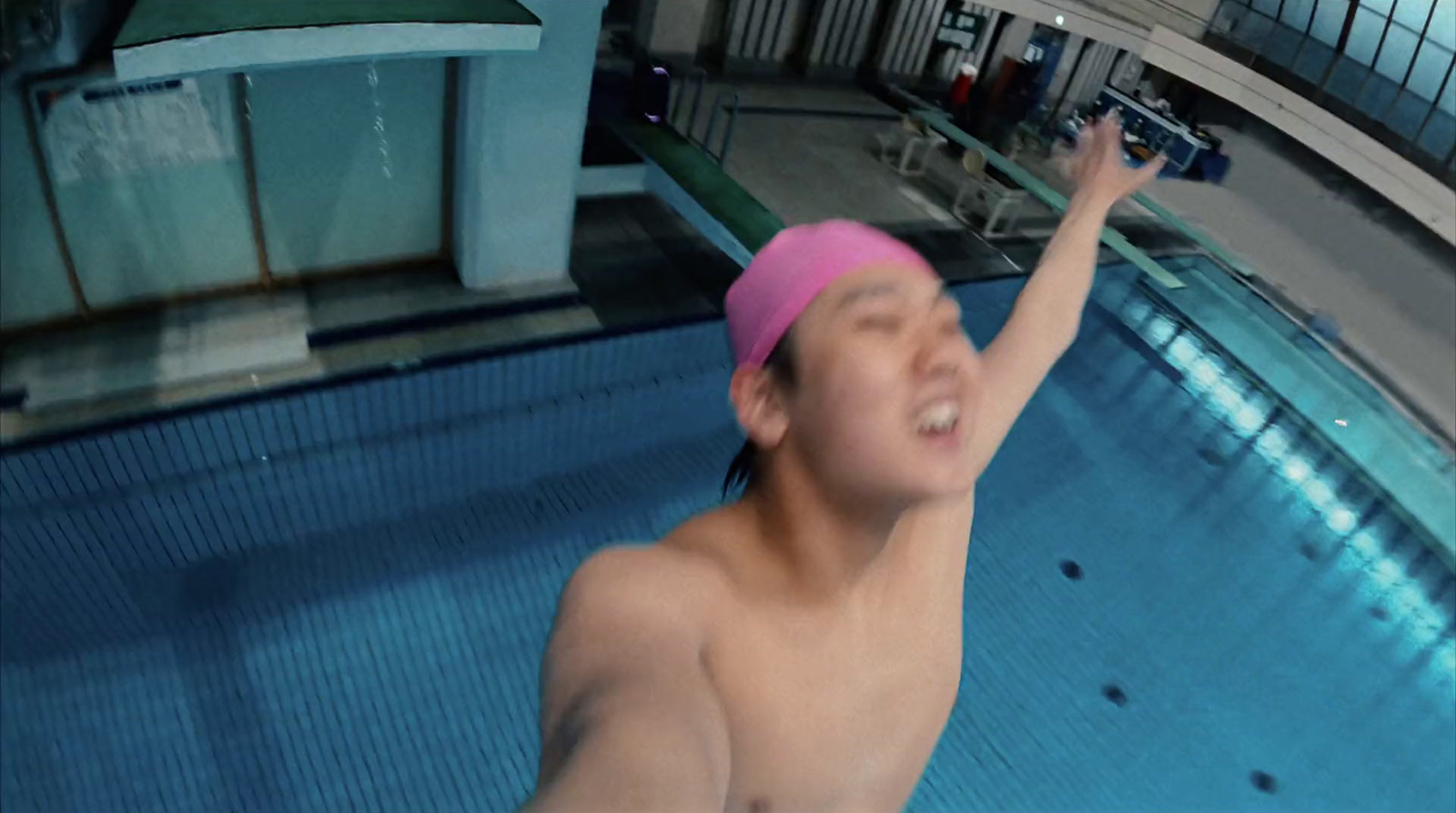 a man in a swimming pool wearing a pink hat