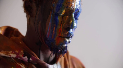 a man is covered in multicolored paint