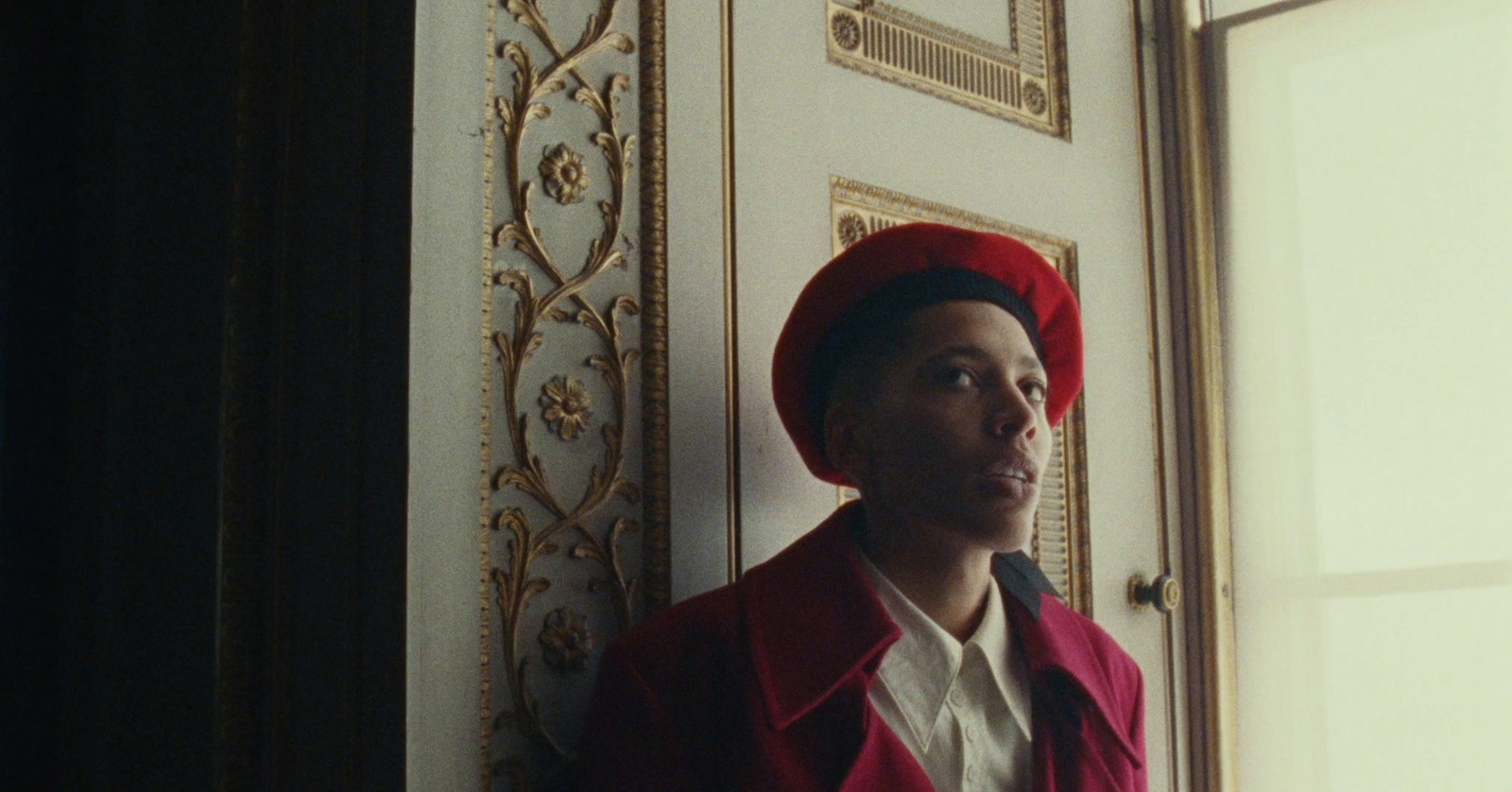 a man wearing a red hat standing in front of a door