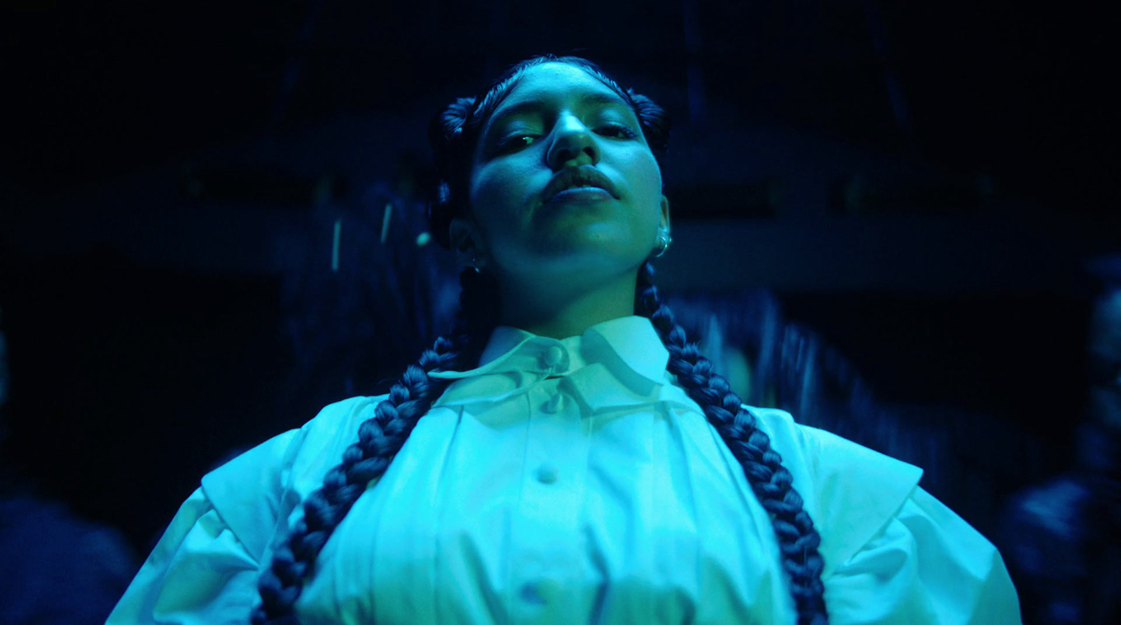 a woman with braids standing in a dark room